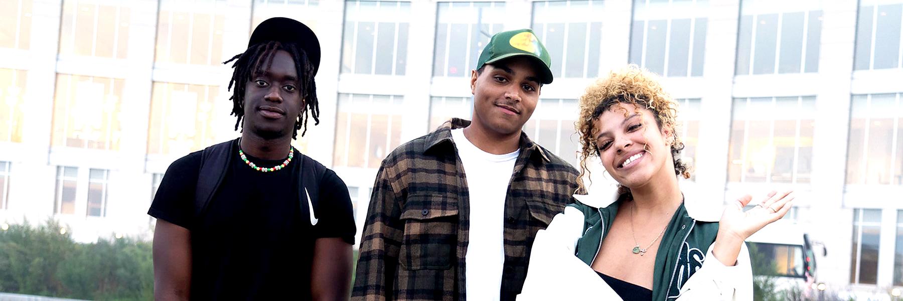 Three students pose outside of the campus center